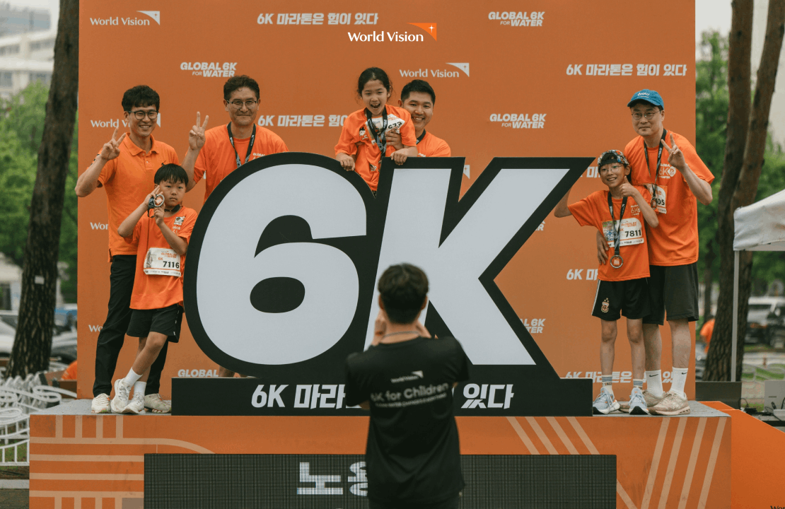 2025 글로벌 6K 마라톤 서울 대회에서 기념 사진을 찍고 있는 참가자들의 모습입니다. 