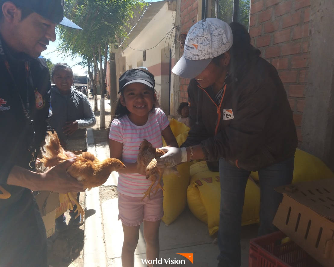 직원이 볼리비아 여자 아이에게 닭을 전해주는 모습