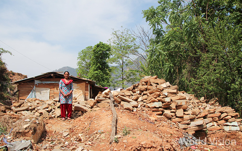 무너진 집 위에 서있는 마이야 씨