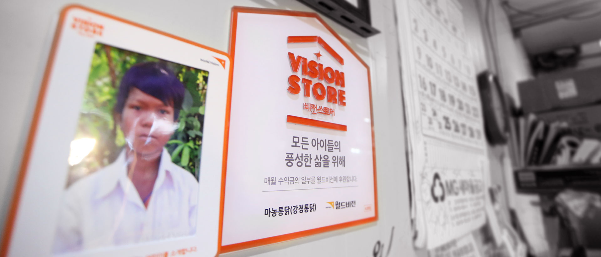 가게 벽에 붙어 있는 자랑스런 비전스토어 명패와 후원아동