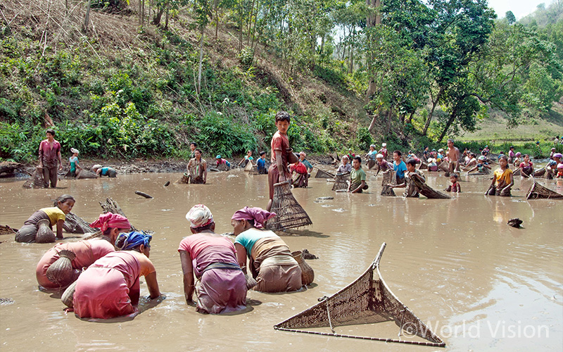 마을 주민들이 모두 모여 강가에 손을 담그고 있네요