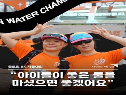 글로벌 6K 참가자 두 명이 주황색 티셔츠를 입고 웃으며 손으로 포즈를 취하고 있다.