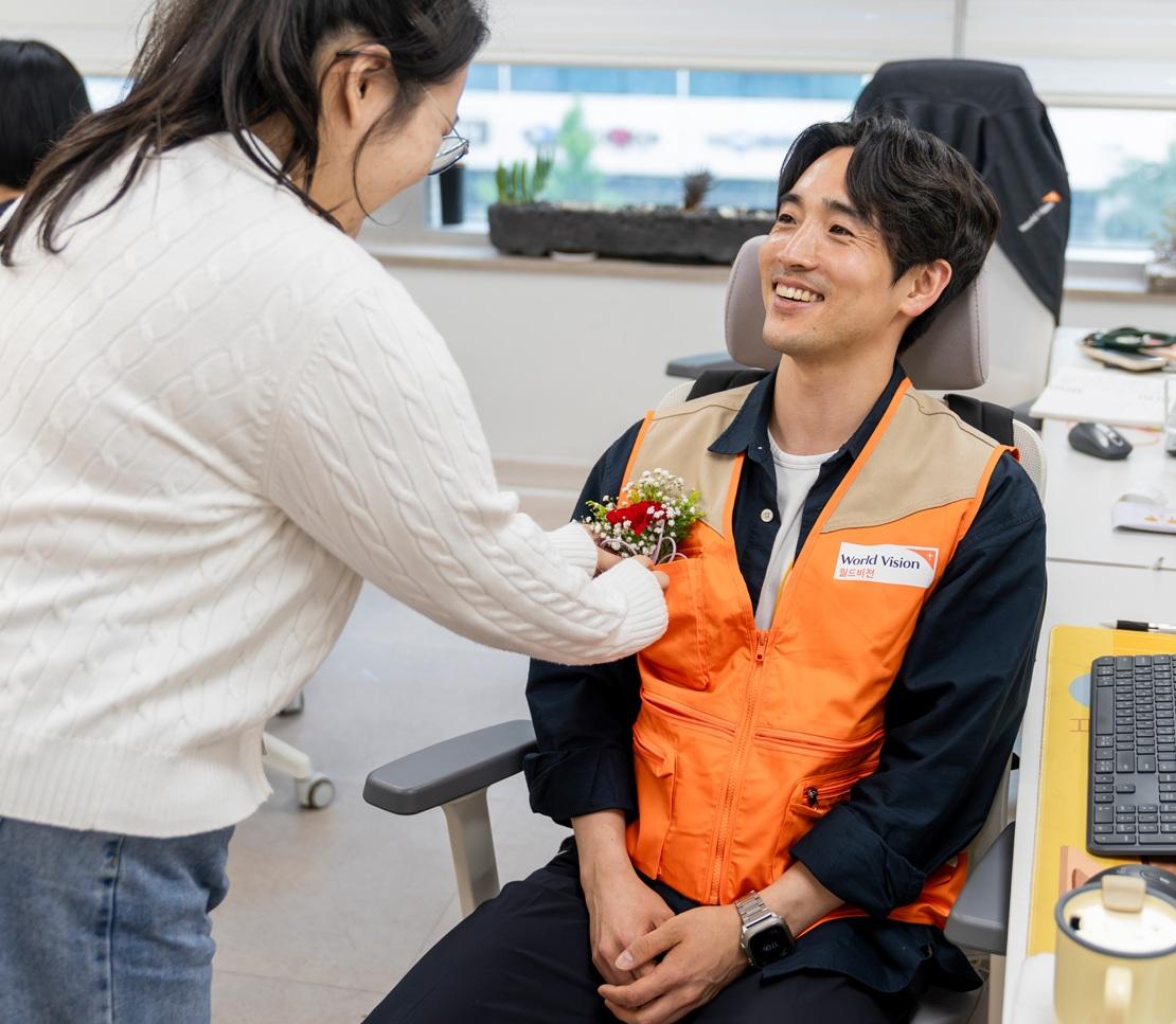 청년이 주는 꽃을 받고 있는 월드비전 부산사업본부 복지사업팀 이재범 과장